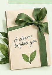 A gift box tied with a green ribbon and a tag reading “A clearer brighter you”